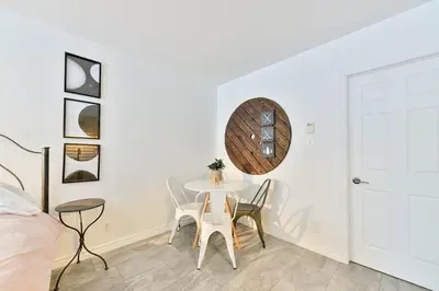 a white dining room with a table and chairs at Suite 3 - Val-Racine in Notre-Dame-Des-Bois