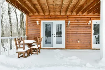a wooden cabin with a table and chairs in the snow at Suite 3 - Val-Racine in Notre-Dame-Des-Bois