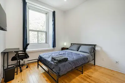 a bedroom with a bed and a desk and a window at Cozy Studio Near Downtown Montreal with Parking in Montréal