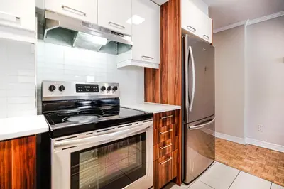 a kitchen with a stove and a refrigerator at Downtown Montreal 2-Bedroom Gem near Bell Centre in Montréal