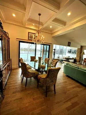 a dining room with a table and chairs and a chandelier at Maison prestige sur la rive in Laval