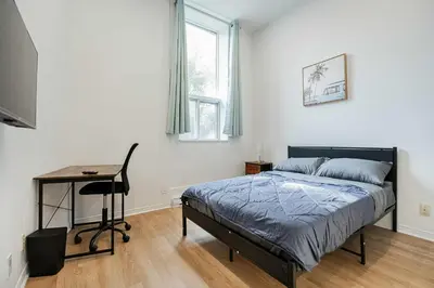 a bedroom with a bed and a desk in it at Great apartment with parking in Montréal