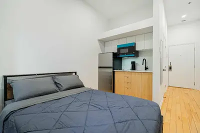 a bedroom with a bed and a kitchen at Fabulous Studio with FREE Parking near Montreal Downtown in Montréal