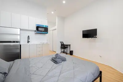 a bedroom with a bed and a kitchen at Magnificent Studio with FREE parking near downtown in Montréal