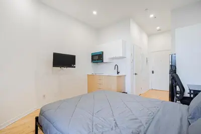 a bedroom with a bed and a tv on the wall at Magnificent Studio with FREE parking near downtown in Montréal