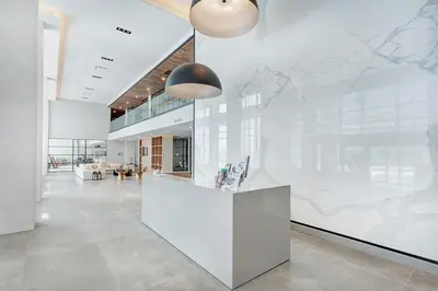 an office lobby with a large white wall with a mural at Corporate Stays Equinoxe 2 Bedroom in Laval