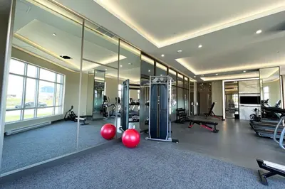 a gym with cardio equipment in a large room with mirrors at Corporate Stays Monarc 2 Bedroom in Montréal