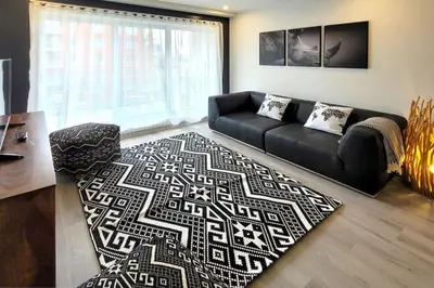 a living room with a black couch and a rug at Corporate Stays Blum 1 Bedroom in Brossard
