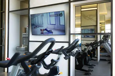 a gym with rows of treadmills and a flat screen tv at Corporate Stays Monarc 2 Bedrooms in Montréal
