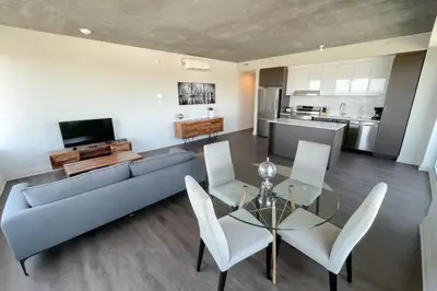 a living room with a couch and a table and chairs at Corporate Stays Monarc 2 Bedrooms in Montréal