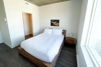 a bedroom with a large white bed and a window at Corporate Stays Monarc 2 Bedrooms in Montréal