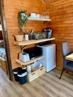 a kitchen with wooden walls with shelves and a microwave at chalet 2 - Domaine de l'Archipel in Sorel