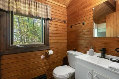 a bathroom with a toilet and a sink and a window at chalet 4 - Domaine de l'Archipel in Sorel