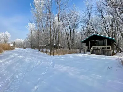 a cabin in the snow with a snow covered road at chalet 5 Domaine de l'Archipel in Sorel