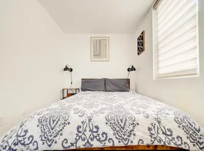 a bedroom with a bed with a blue and white comforter at Griffintown Cozy Haven in Montréal