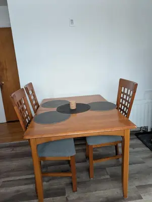a wooden table with two chairs and a table at Chambre confortable 2 pas Hôpital Université Services in Trois-Rivières