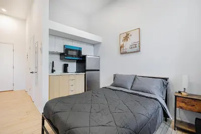 a bedroom with a bed and a kitchen with a refrigerator at Studio pour 2 voyageurs- location par semaine avec un parking gratuit in Montréal