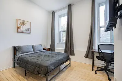 a bedroom with a bed and a desk and windows at Studio pour 2 voyageurs- location par semaine avec un parking gratuit in Montréal