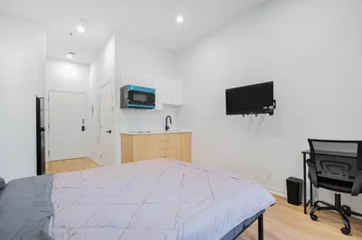a bedroom with a bed and a flat screen tv at Studio tout équipe pour 2- Location par semaine- Parking gratuit in Montréal