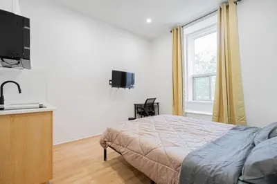 a bedroom with a bed and a flat screen tv at Studio tout équipe pour 2- Location par semaine- Parking gratuit in Montréal