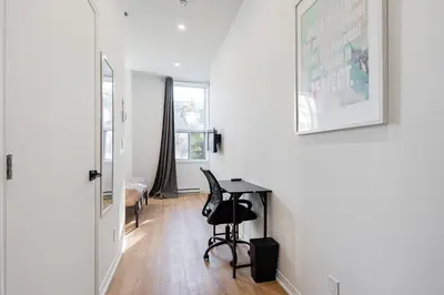 a white room with a desk and a bedroom at Studio style pour 2- Location par Semaine-Parking gratuit in Montréal