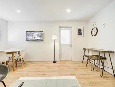 a living room with a table and chairs and a clock at Appartement central à Montréal - À deux pas de tout in Montréal