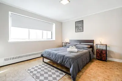 a bedroom with a bed and a large window at Appartement chaleureux pour un séjour parfait in Montréal