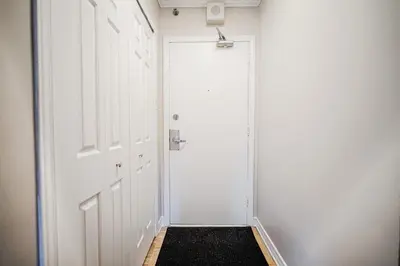 a hallway with a white door and a black rug at Appartement chaleureux pour un séjour parfait in Montréal