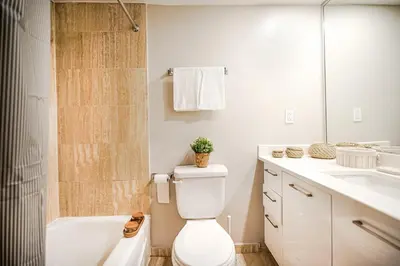 a bathroom with a toilet and a tub and a sink at Appartement chaleureux pour un séjour parfait in Montréal