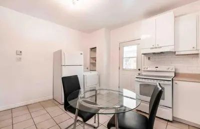 a kitchen with a glass table and white appliances at FULL KITCHEN 6min from DTOWN Room B in Montréal