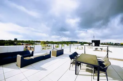 a balcony with couches and chairs on a roof at 203 - Fantastic Cozy New 2 Queen Condo with Gym, DT&Airport in Montréal
