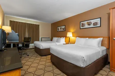a hotel room with two beds and a flat screen tv at Comfort Inn in Drummondville