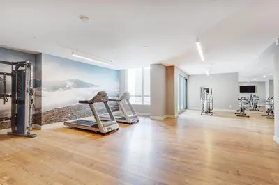a gym with cardio equipment in a building at L'Equinox Modern Apartments by Corporate Stays in Laval
