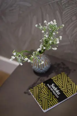 a vase with white flowers sitting on a table at The Santamaria Golden Palms Studio by Den Stays in Montréal