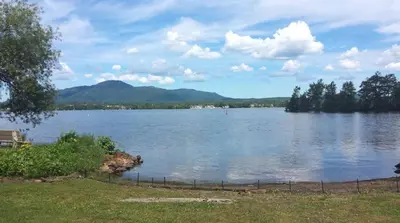 a view of a large lake with mountains in the background at Magog Waterfront Studio 106 in Magog-Orford