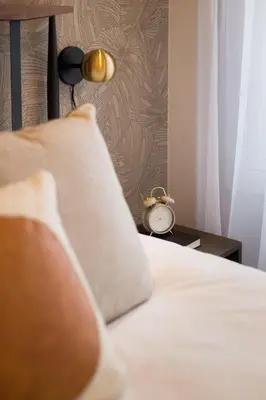 a bed with a pillow and a clock on a table at Blue Oasis Studio with Full Kitchen and Bath by Den Stays in Montréal