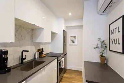 a kitchen with a sink and a counter top at Blue Oasis Studio with Full Kitchen and Bath by Den Stays in Montréal