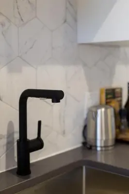a kitchen sink with a black kitchen faucet at Romantic Studio in the Heart of Little Italy by Den Stays in Montréal