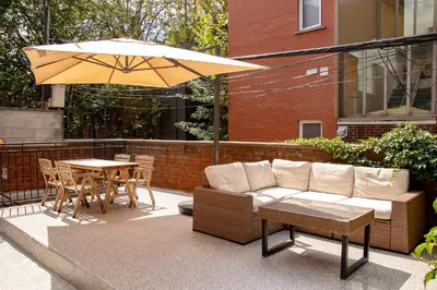 a patio with a couch and a table and an umbrella at BOHEMIAN - SelfCheckIn - Rooftop - Terraces - St-Denis in Montréal