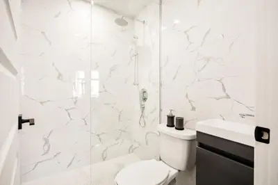 a white bathroom with a toilet and a shower at Le Mile End by M11 - Upscale 1 BDR with Sofa Bed in Montréal