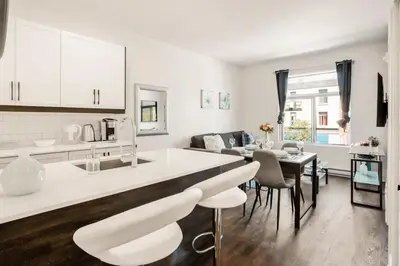a kitchen and living room with a table and chairs at Le Mile End by M11 - Upscale 1 BDR with Sofa Bed in Montréal