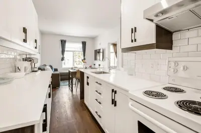 a kitchen with white counters and a stove top oven at Le Mile End by M11 - Upscale 1 BDR with Sofa Bed in Montréal