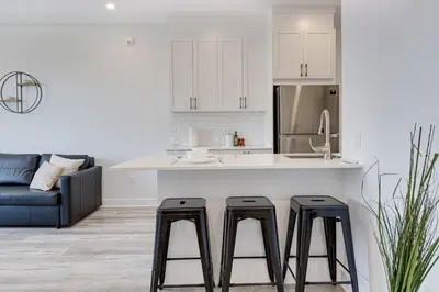 a kitchen with a counter and two stools in a kitchen at Le Mile End by M11 - Upscale & Spacious 1BDR with King Bed in Montréal