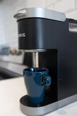 a coffee maker is making a cup of coffee at Le Mile End by M11 - Upscale & Spacious 1BDR with King Bed in Montréal