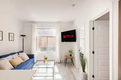 a living room with a blue couch and a window at Le Mile End by M11 - Modern 2BDR with Sofa Bed in Montréal
