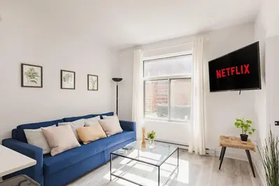 a living room with a blue couch and a window at Le Mile End by M11 - Spacious 2BDR Unit with Sofa Bed in Montréal