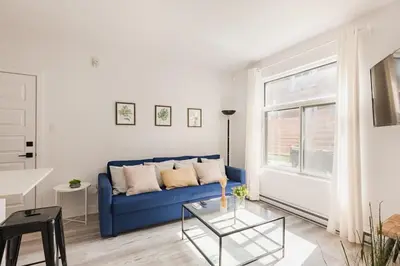 a living room with a blue couch and a table at Le Mile End by M11 - Spacious 2BDR Unit with Sofa Bed in Montréal